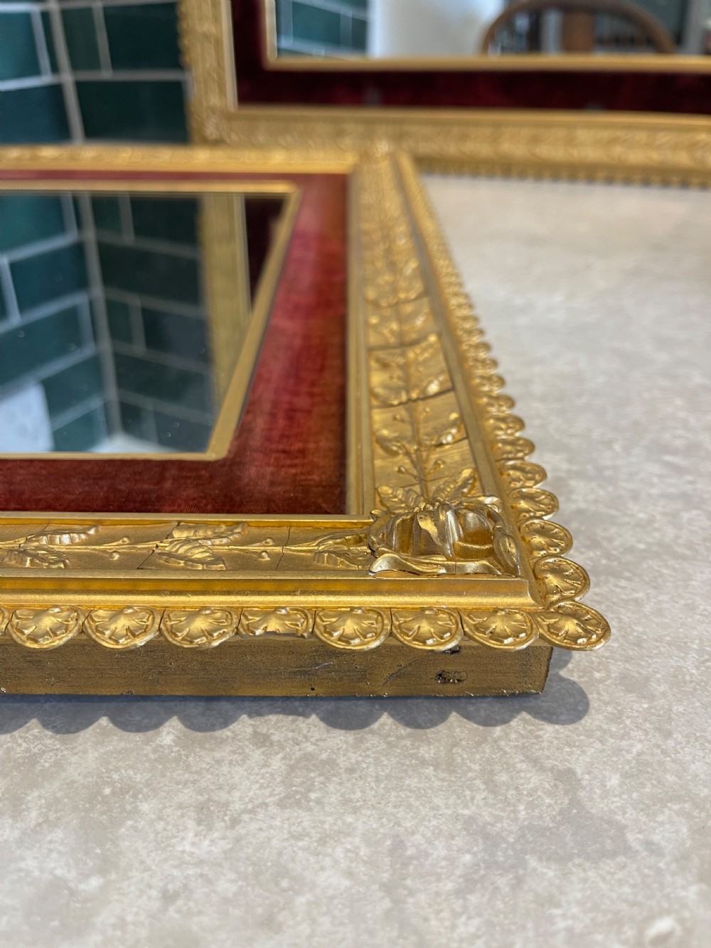 A pair of nineteenth-century rectangular mirrors featuring gold gilt frames decorated with leaf mouldings and lined with inner borders of crimson red velvet. View II