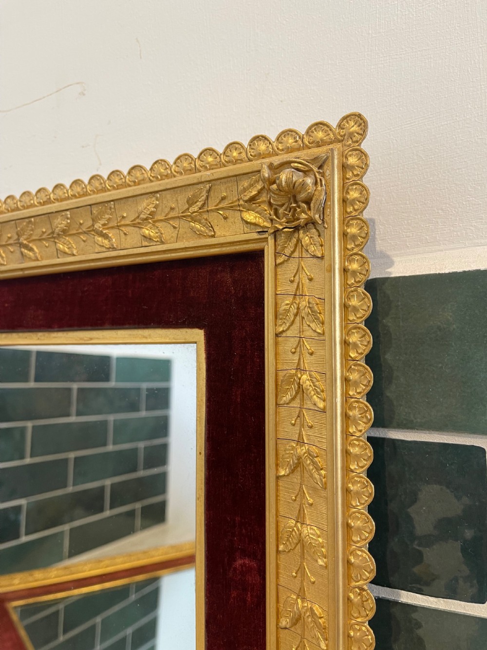 A pair of nineteenth-century rectangular mirrors featuring gold gilt frames decorated with leaf mouldings and lined with inner borders of crimson red velvet. View V