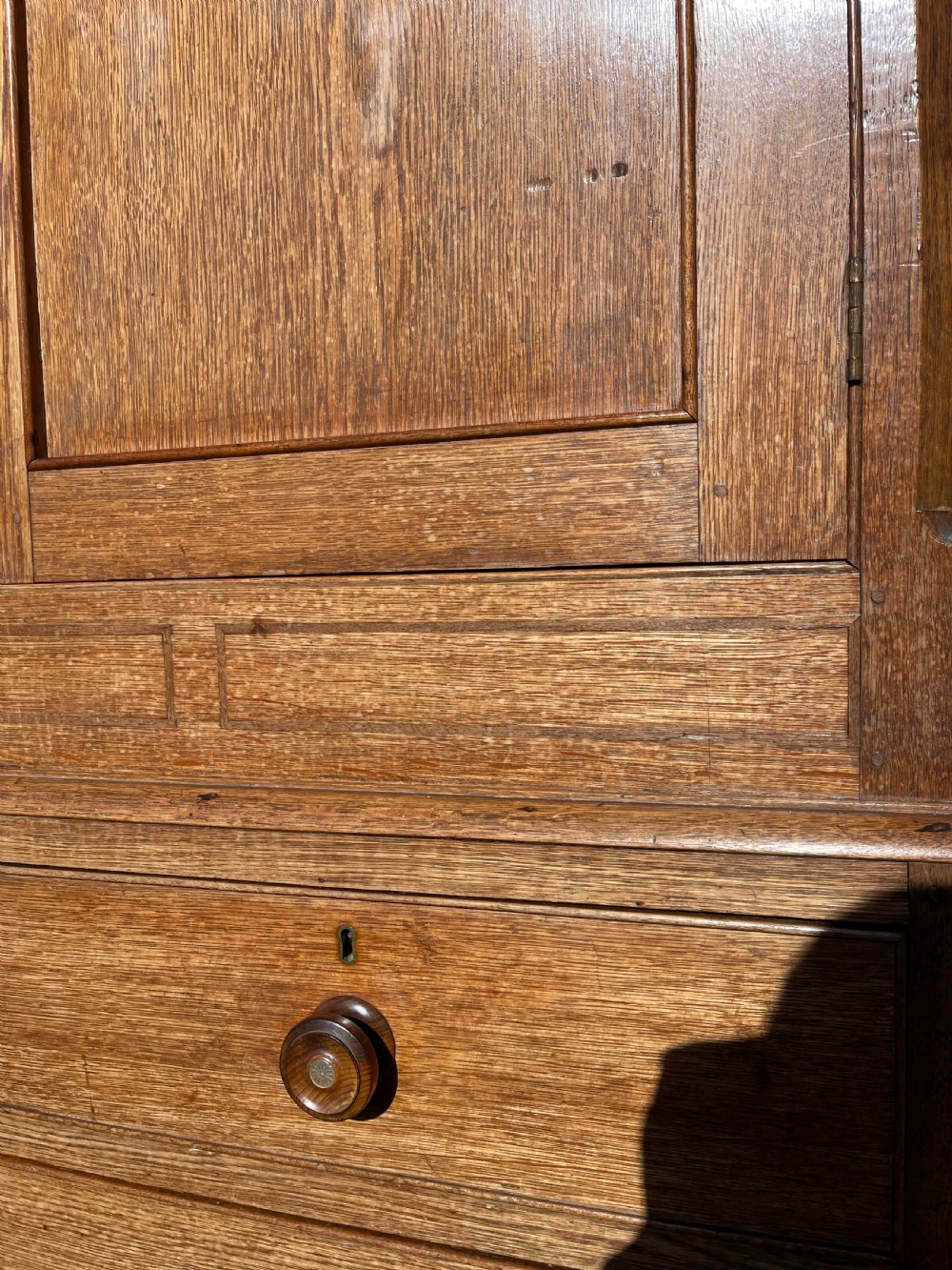 A nineteenth-century Welsh oak press cupboard featuring an upper double-door section with arched fielded panels over a base with four drawers. View II