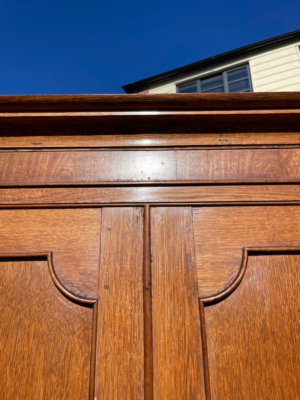 A nineteenth-century Welsh oak press cupboard featuring an upper double-door section with arched fielded panels over a base with four drawers. View III