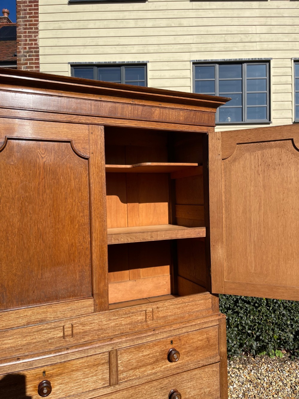 A nineteenth-century Welsh oak press cupboard featuring an upper double-door section with arched fielded panels over a base with four drawers. View IV
