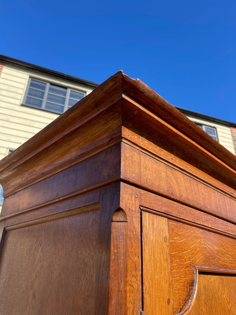 A nineteenth-century Welsh oak press cupboard featuring an upper double-door section with arched fielded panels over a base with four drawers. View VI