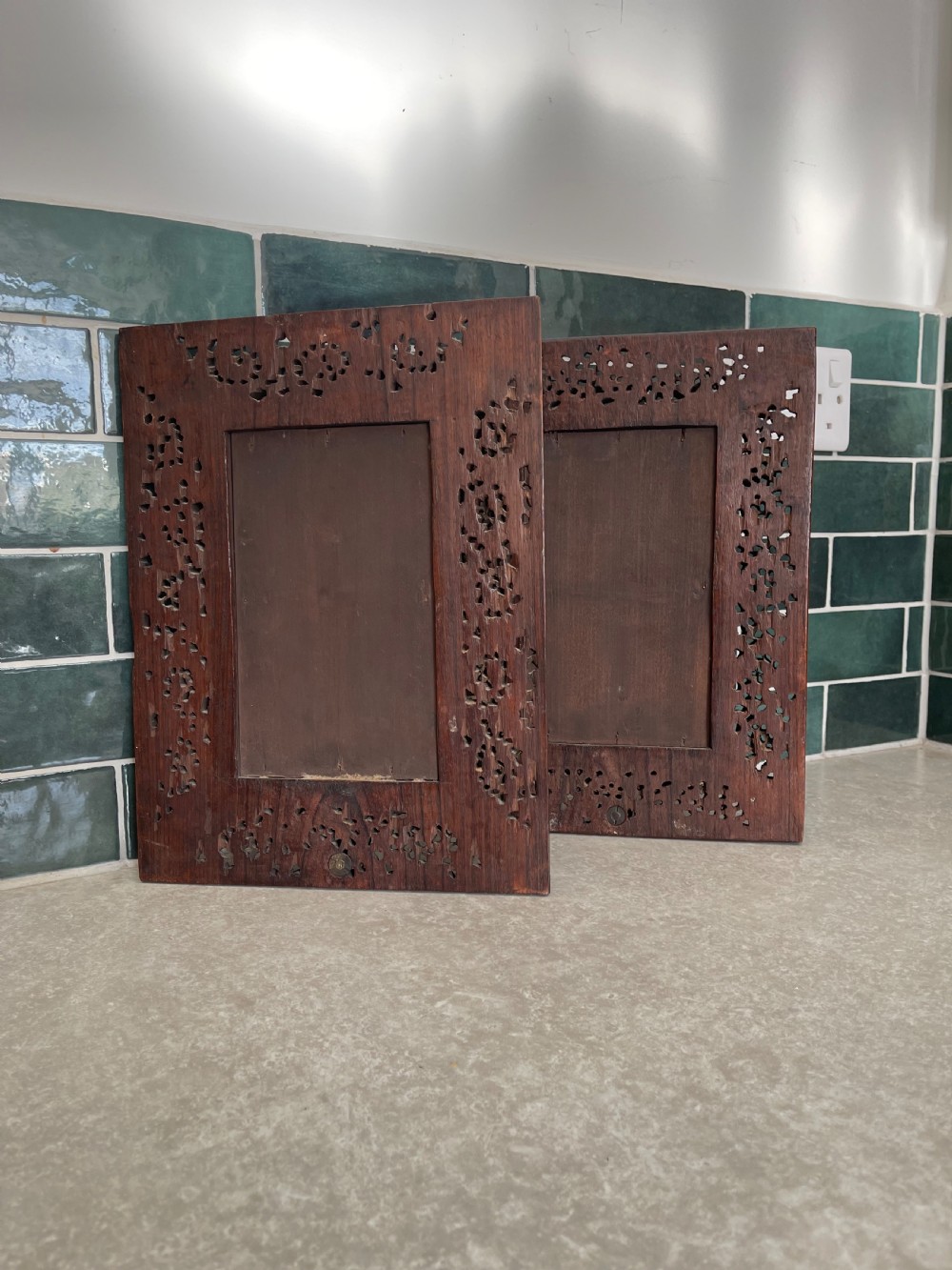 A pair of rectangular dark carved hardwood wall sconces featuring intricate floral openwork frames, inset rectangular mirrors, and central brass candle arms. View IV