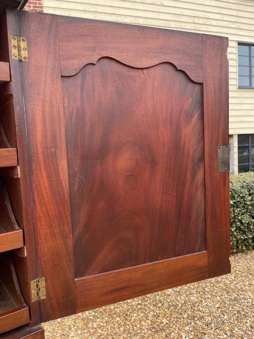 A tall Georgian mahogany secretaire press cupboard featuring two panelled doors above drawers with brass handles, resting on bracket feet. View VII