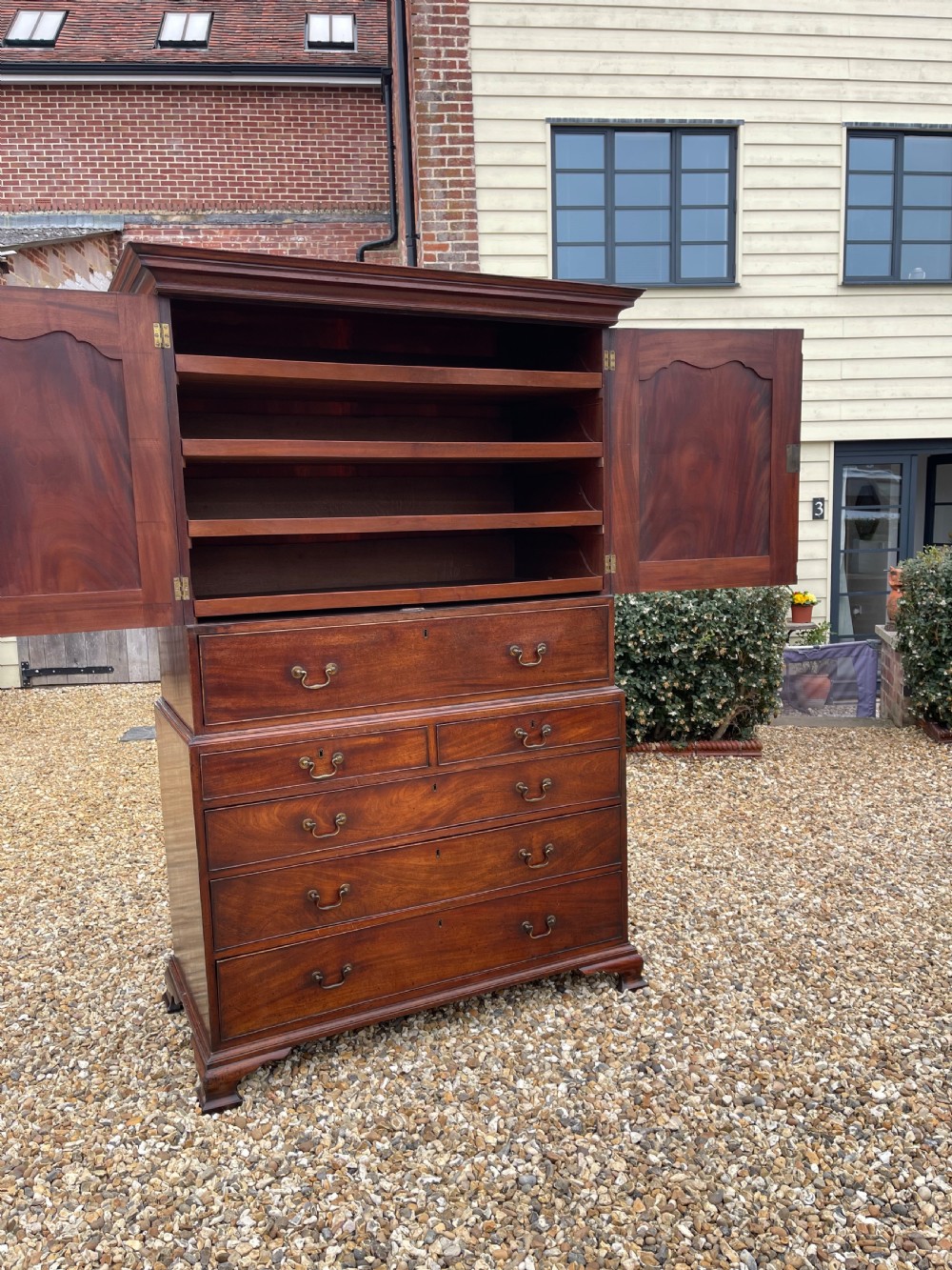 A tall Georgian mahogany secretaire press cupboard featuring two panelled doors above drawers with brass handles, resting on bracket feet. View VIII