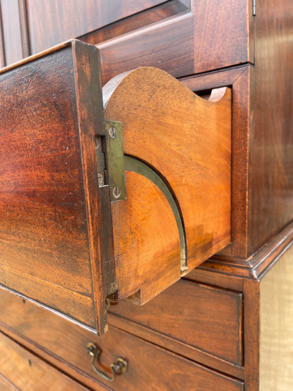 A tall Georgian mahogany secretaire press cupboard featuring two panelled doors above drawers with brass handles, resting on bracket feet. View IX