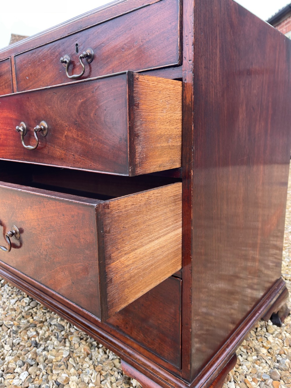 A tall Georgian mahogany secretaire press cupboard featuring two panelled doors above drawers with brass handles, resting on bracket feet. View XI