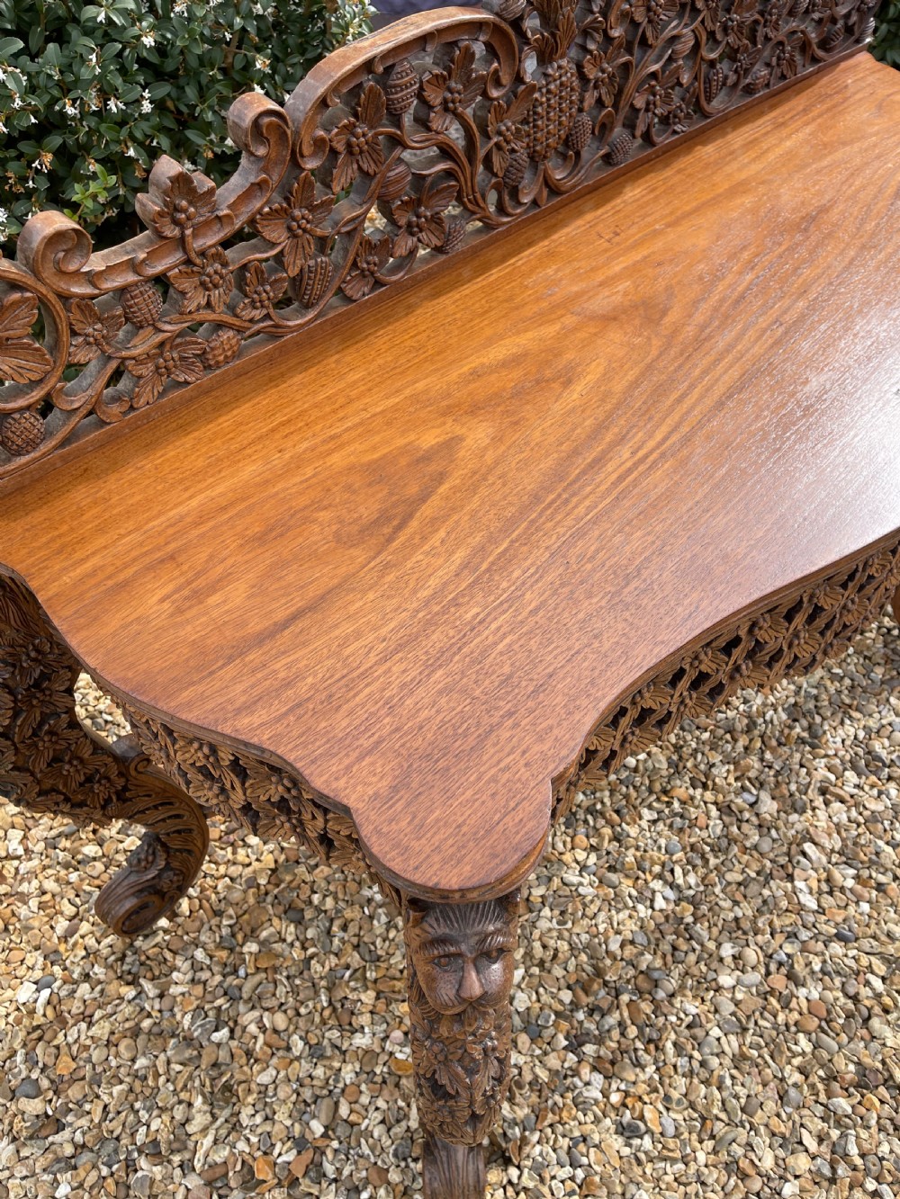 A nineteenth-century Anglo-Indian carved wood console table featuring a detailed openwork apron, gallery back, and intricately carved leg supports. View IV