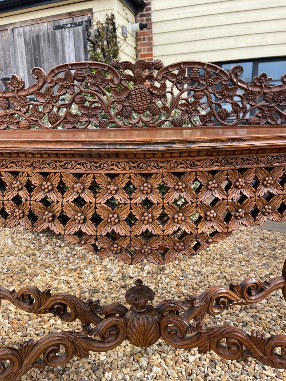 A nineteenth-century Anglo-Indian carved wood console table featuring a detailed openwork apron, gallery back, and intricately carved leg supports. View VII
