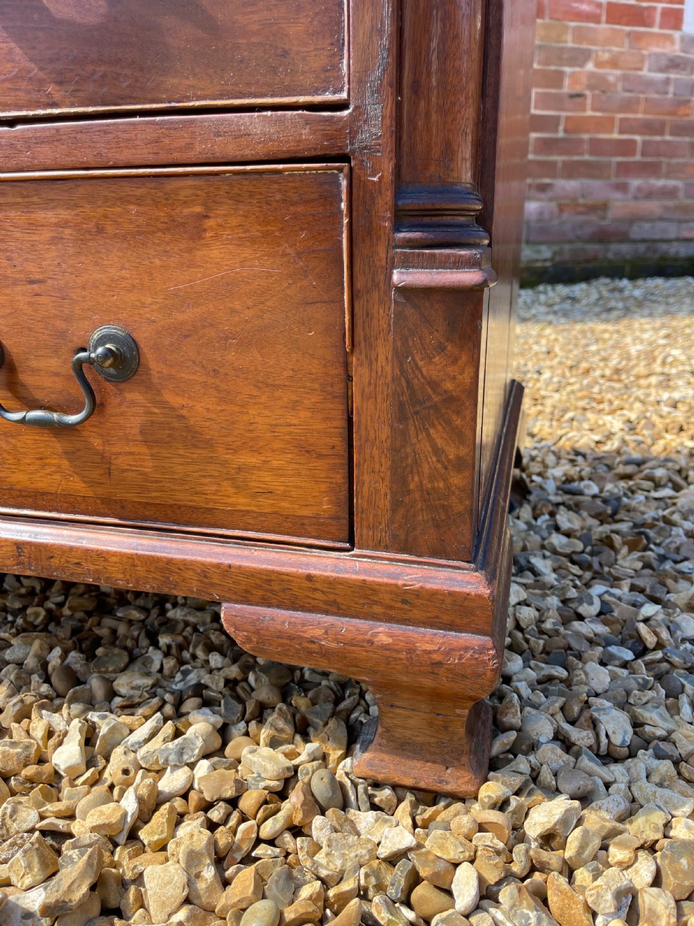 An eighteenth-century Georgian mahogany chest of drawers featuring two short drawers over three long drawers, finished with brass swan-neck handles and bracket feet. View III