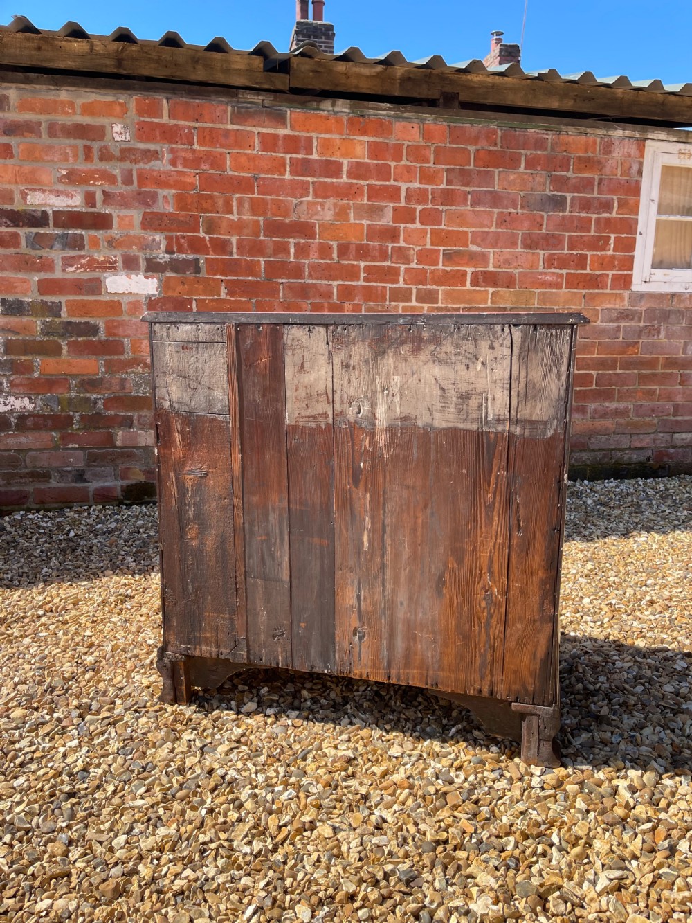 An eighteenth-century Georgian mahogany chest of drawers featuring two short drawers over three long drawers, finished with brass swan-neck handles and bracket feet. View VI
