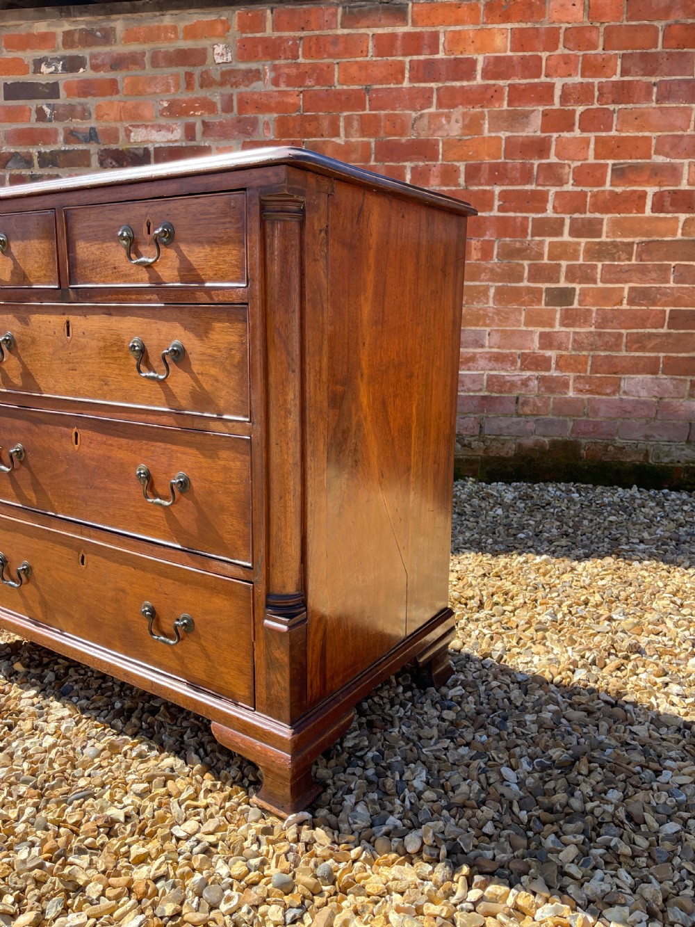 An eighteenth-century Georgian mahogany chest of drawers featuring two short drawers over three long drawers, finished with brass swan-neck handles and bracket feet. View XI
