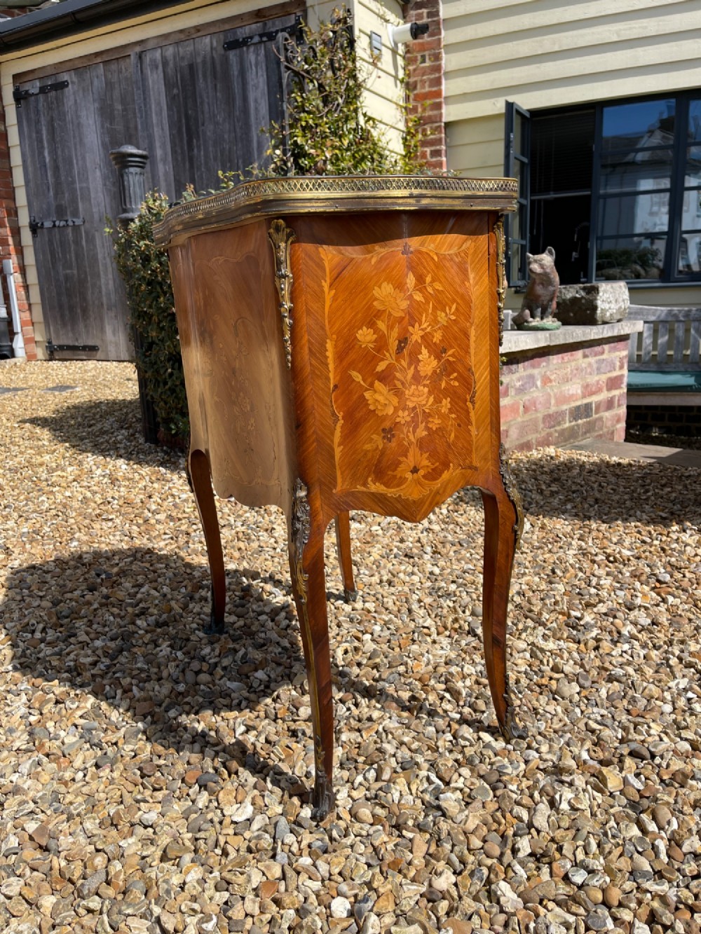 A late nineteenth-century French style side cabinet featuring floral marquetry wood inlay, a variegated marble top surrounded by a pierced brass gallery rim, cabriole legs, and a glazed door. View III