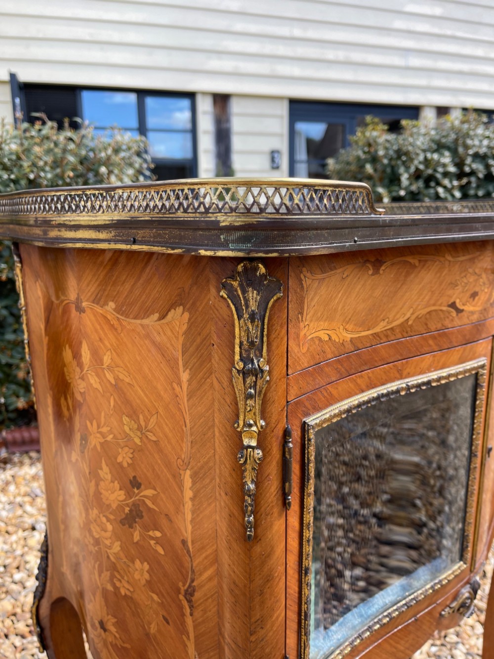 A late nineteenth-century French style side cabinet featuring floral marquetry wood inlay, a variegated marble top surrounded by a pierced brass gallery rim, cabriole legs, and a glazed door. View VIII