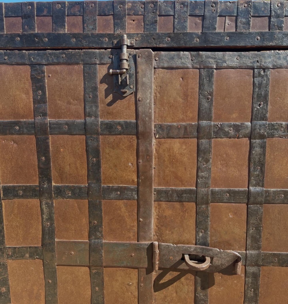 A tall nineteenth-century Indian wooden cupboard bound in dark iron lattice strapping with metal latches and double doors. View II