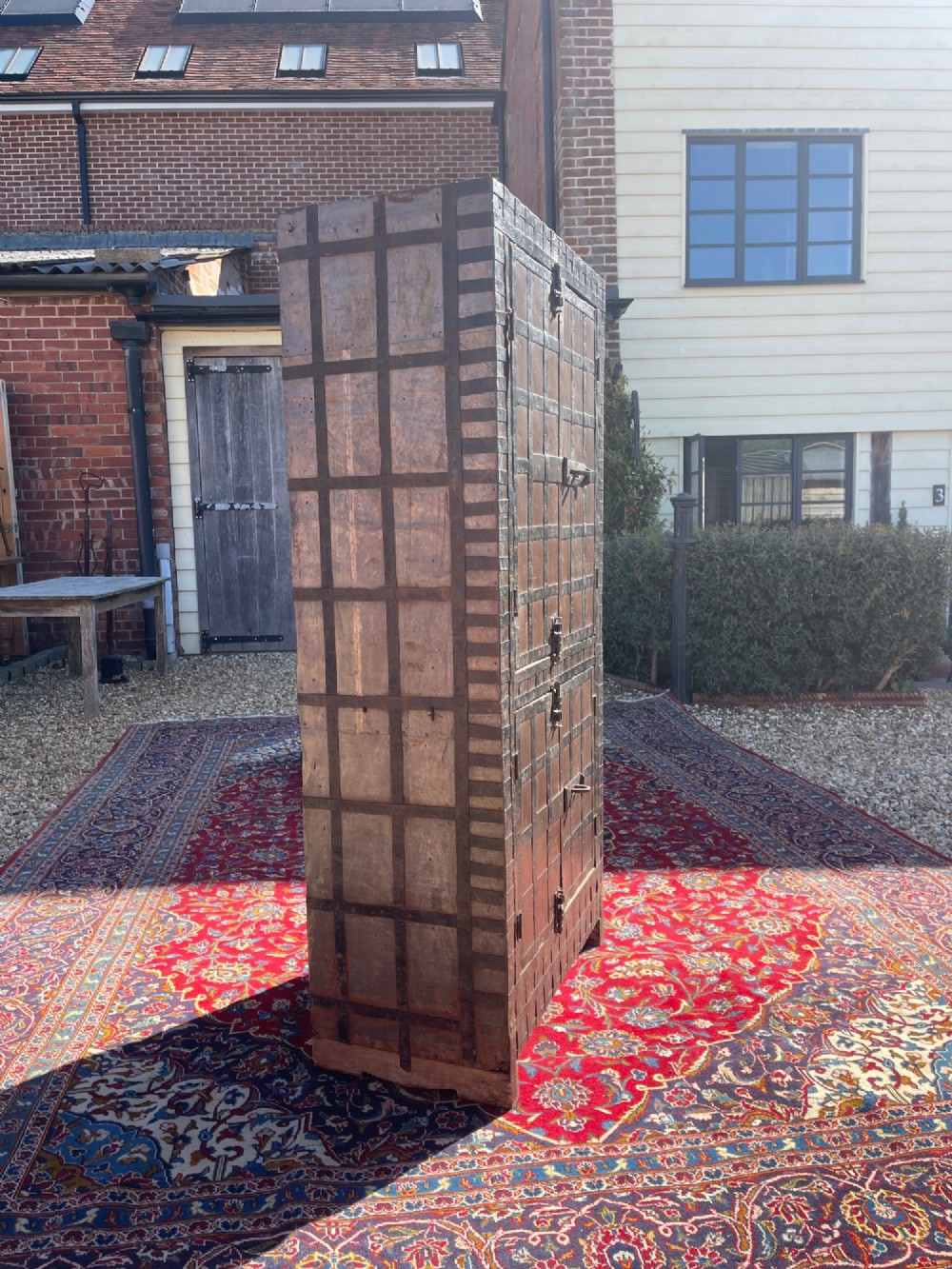 A tall nineteenth-century Indian wooden cupboard bound in dark iron lattice strapping with metal latches and double doors. View VIII