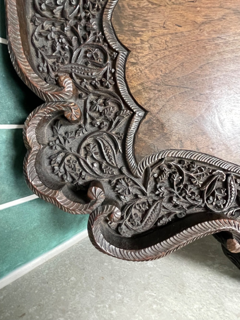 A dark brown carved walnut tray featuring a smooth central panel surrounded by a scalloped, intricately carved floral border. View III