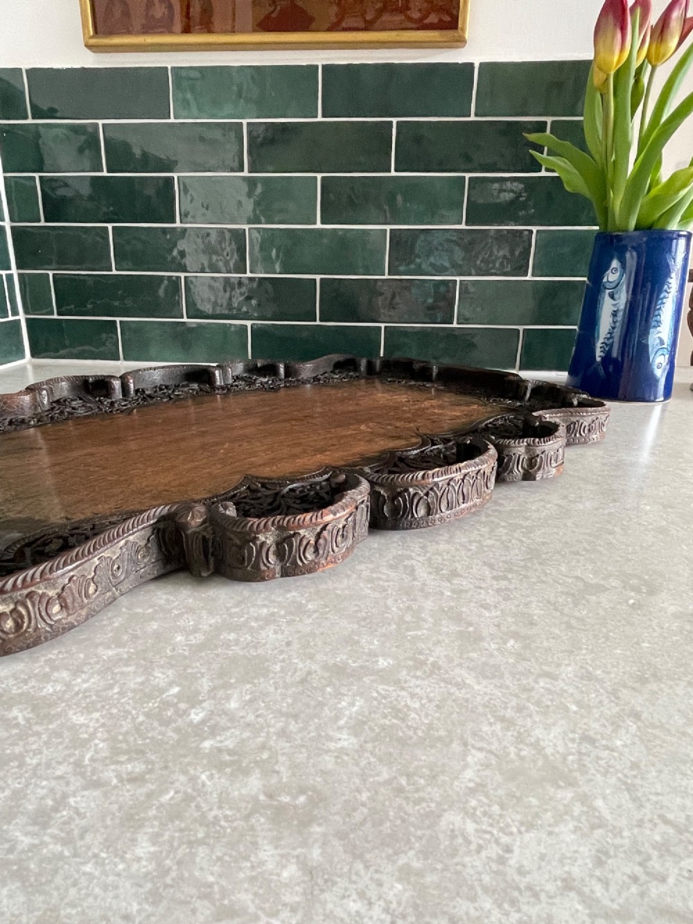 A dark brown carved walnut tray featuring a smooth central panel surrounded by a scalloped, intricately carved floral border. View V