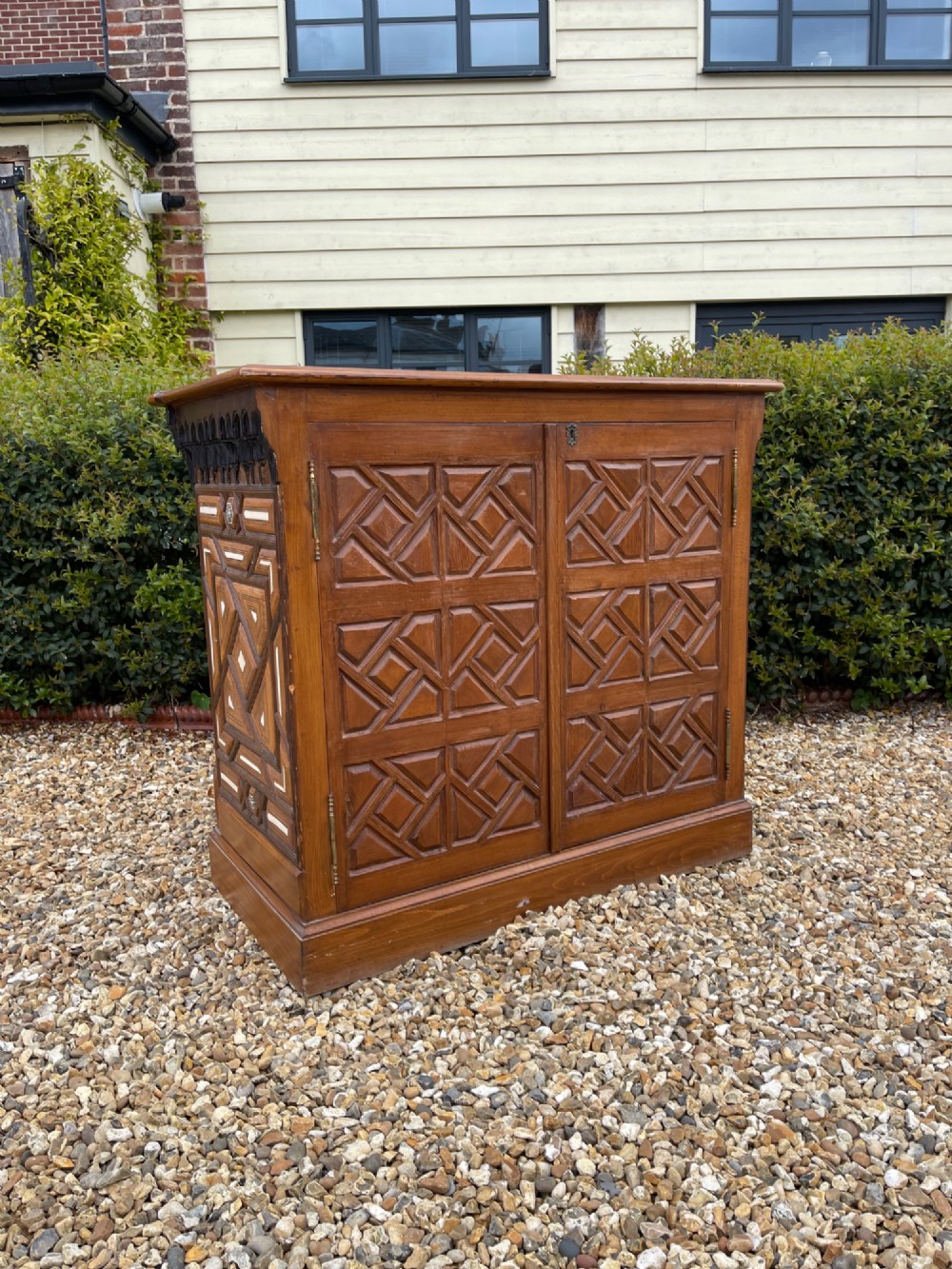 A dark brown rectangular wooden cabinet decorated with geometric bone inlay panels and carved mashrabiya lattice work. View II