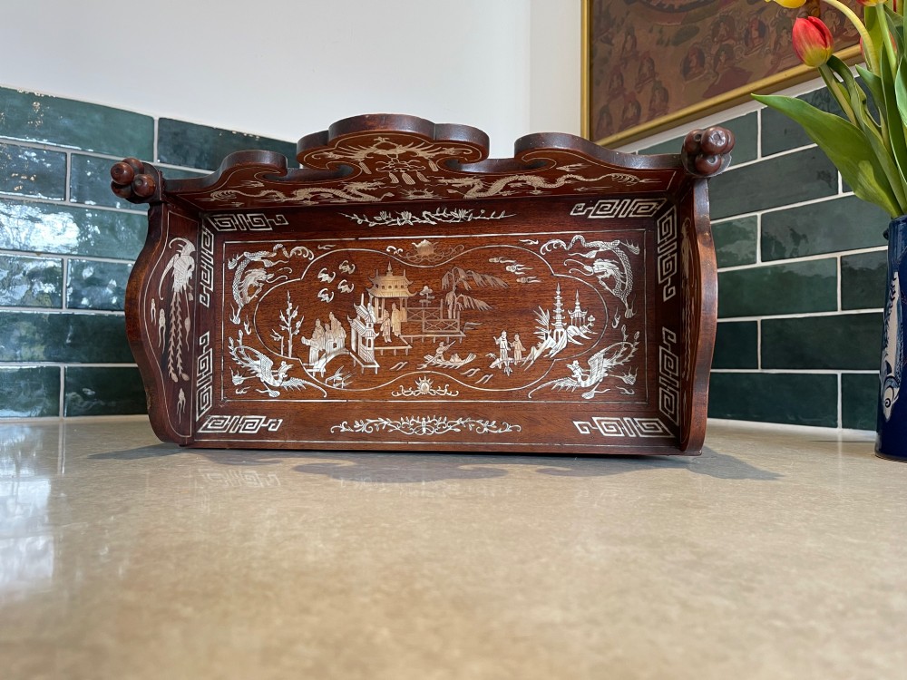 A dark wood Chinese table cabinet featuring two doors embellished with detailed mother-of-pearl landscape inlays, flanked by decorative borders and topped with a carved cresting. View IV