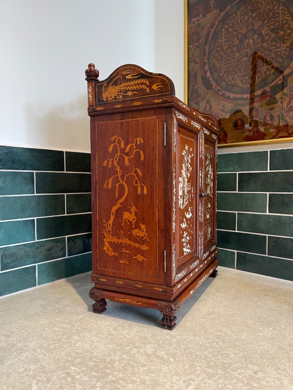 A dark wood Chinese table cabinet featuring two doors embellished with detailed mother-of-pearl landscape inlays, flanked by decorative borders and topped with a carved cresting. View VII