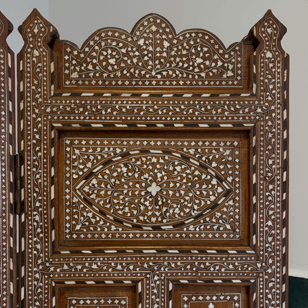 A three-panel Anglo-Indian folding table screen crafted from dark wood with white floral bone inlay patterns. View II