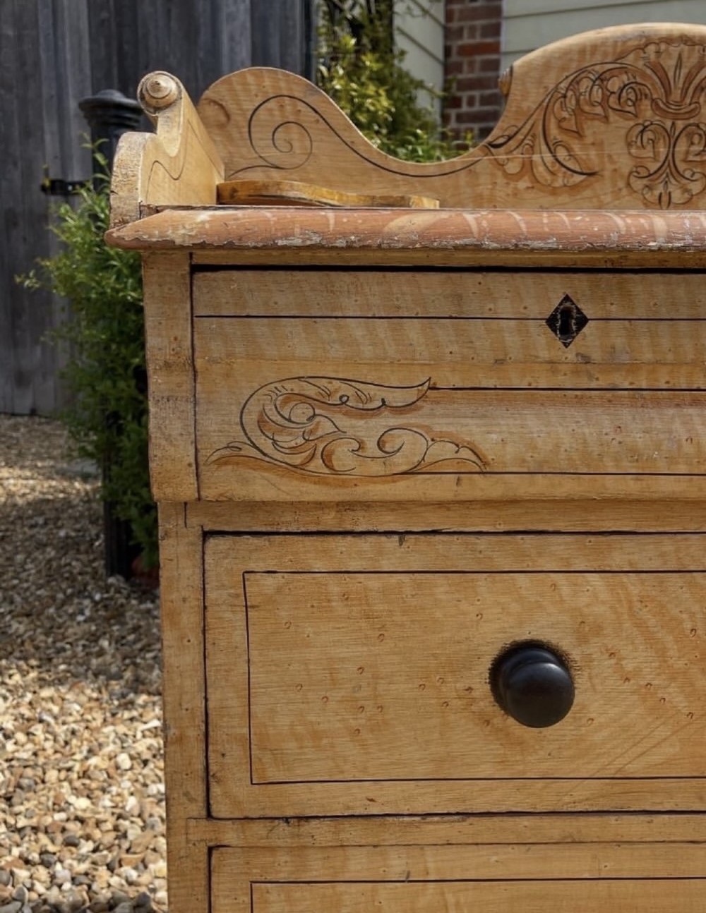 A Victorian painted pine chest of drawers with a carved gallery back, wooden knobs, and turned feet. View III