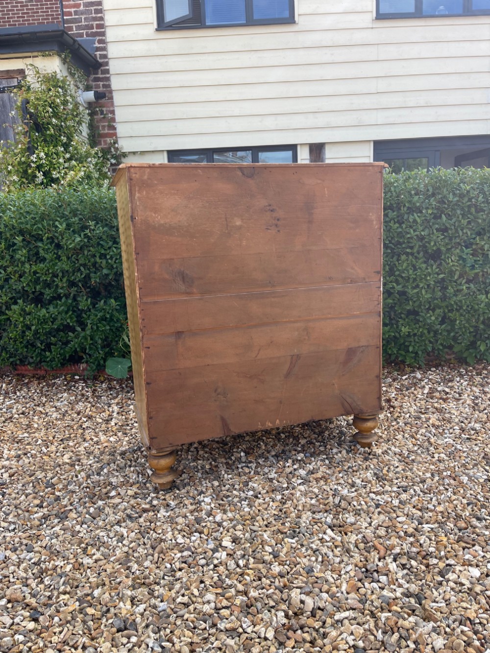 A Victorian pine chest of drawers with an original light brown faux-grain painted finish, featuring two short drawers over three long drawers with turned wooden handles and bun feet. View IV