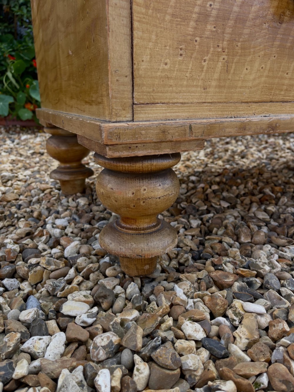 A Victorian pine chest of drawers with an original light brown faux-grain painted finish, featuring two short drawers over three long drawers with turned wooden handles and bun feet. View V