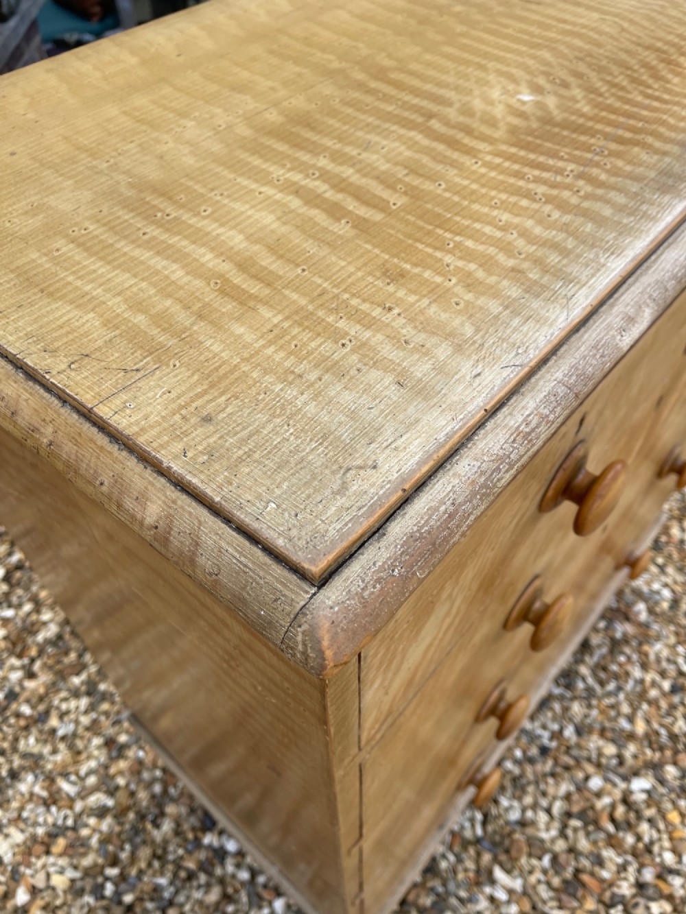 A Victorian pine chest of drawers with an original light brown faux-grain painted finish, featuring two short drawers over three long drawers with turned wooden handles and bun feet. View VI