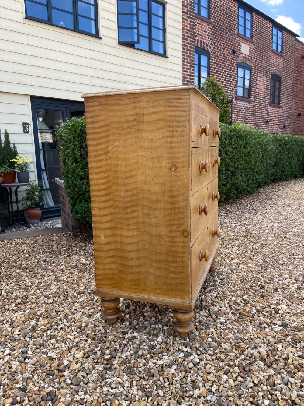 A Victorian pine chest of drawers with an original light brown faux-grain painted finish, featuring two short drawers over three long drawers with turned wooden handles and bun feet. View VII
