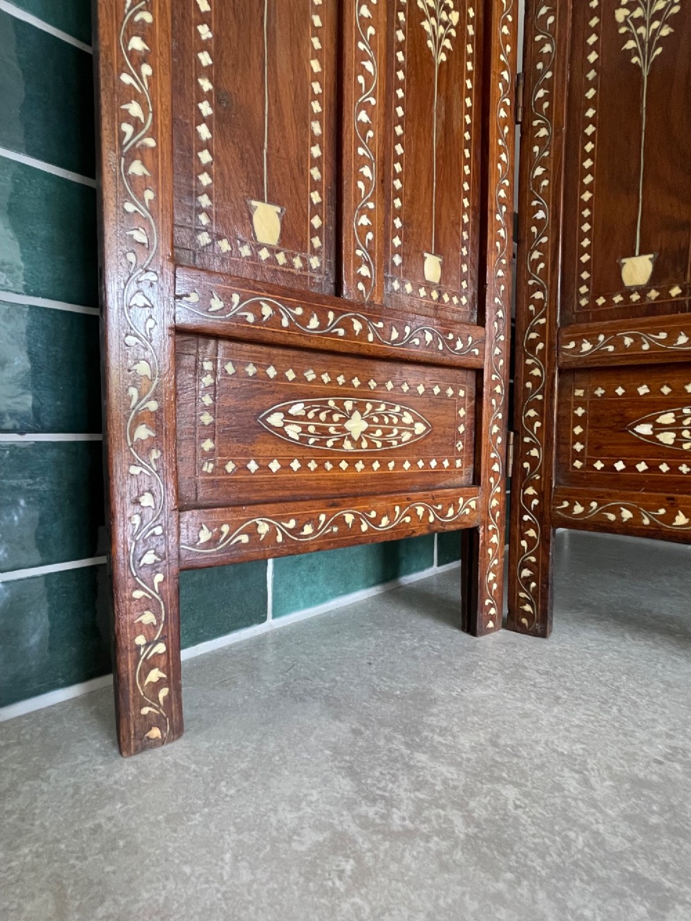 A four-panel Anglo-Indian miniature folding table screen constructed from dark brown wood with dense floral bone inlay decoration. View IV