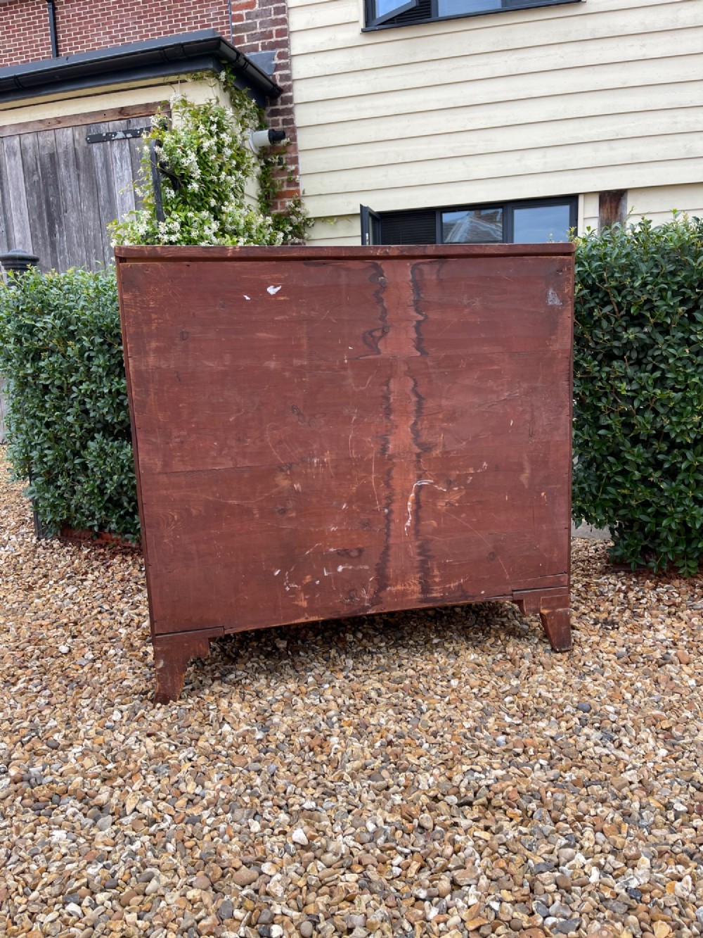 A Georgian mahogany bowfronted chest of drawers featuring two short over three long drawers with turned wooden knobs and splayed bracket feet. View V