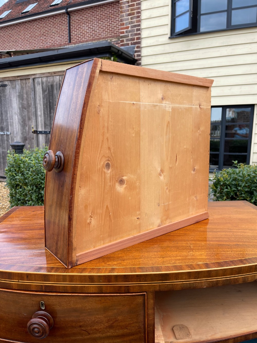 A Georgian mahogany bowfronted chest of drawers featuring two short over three long drawers with turned wooden knobs and splayed bracket feet. View VII