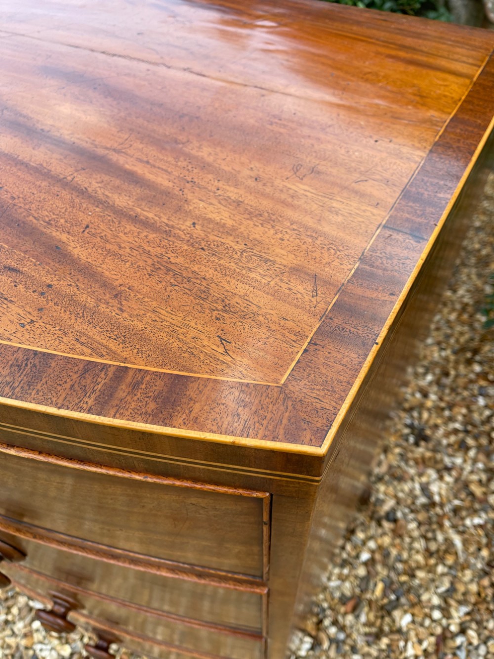 A Georgian mahogany bowfronted chest of drawers featuring two short over three long drawers with turned wooden knobs and splayed bracket feet. View XI