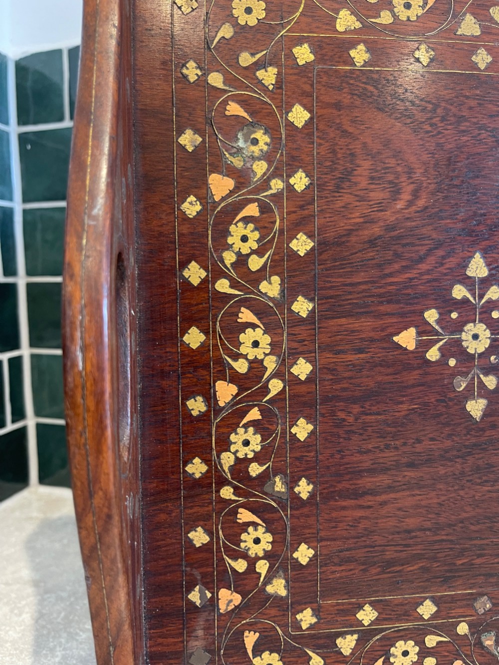 A rectangular dark hardwood serving tray featuring intricate floral and geometric brass inlay with cut-out side handles. View III
