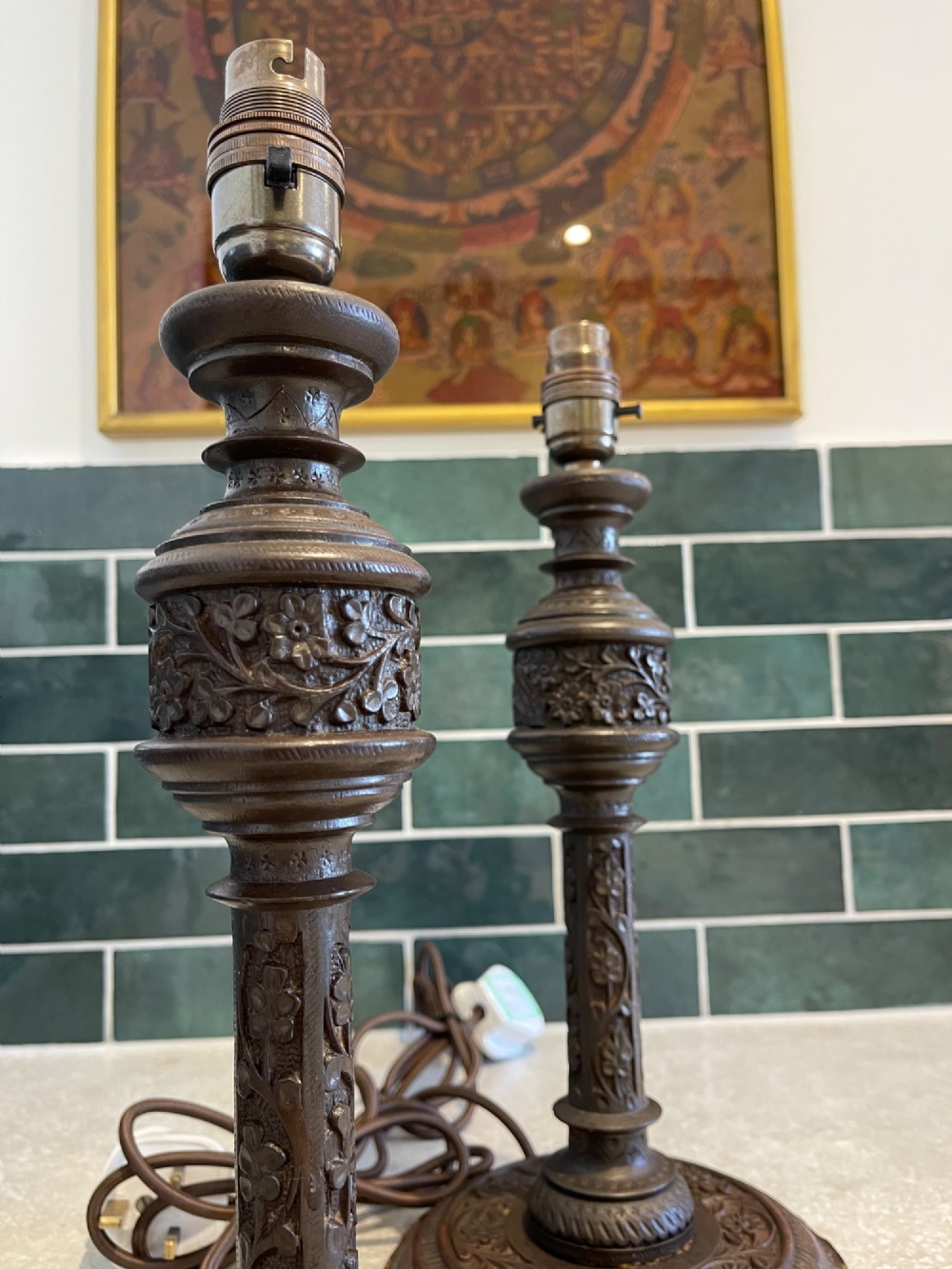 A pair of hand-carved dark brown wooden table lamp bases featuring intricate floral relief detailing and turned shafts. View II