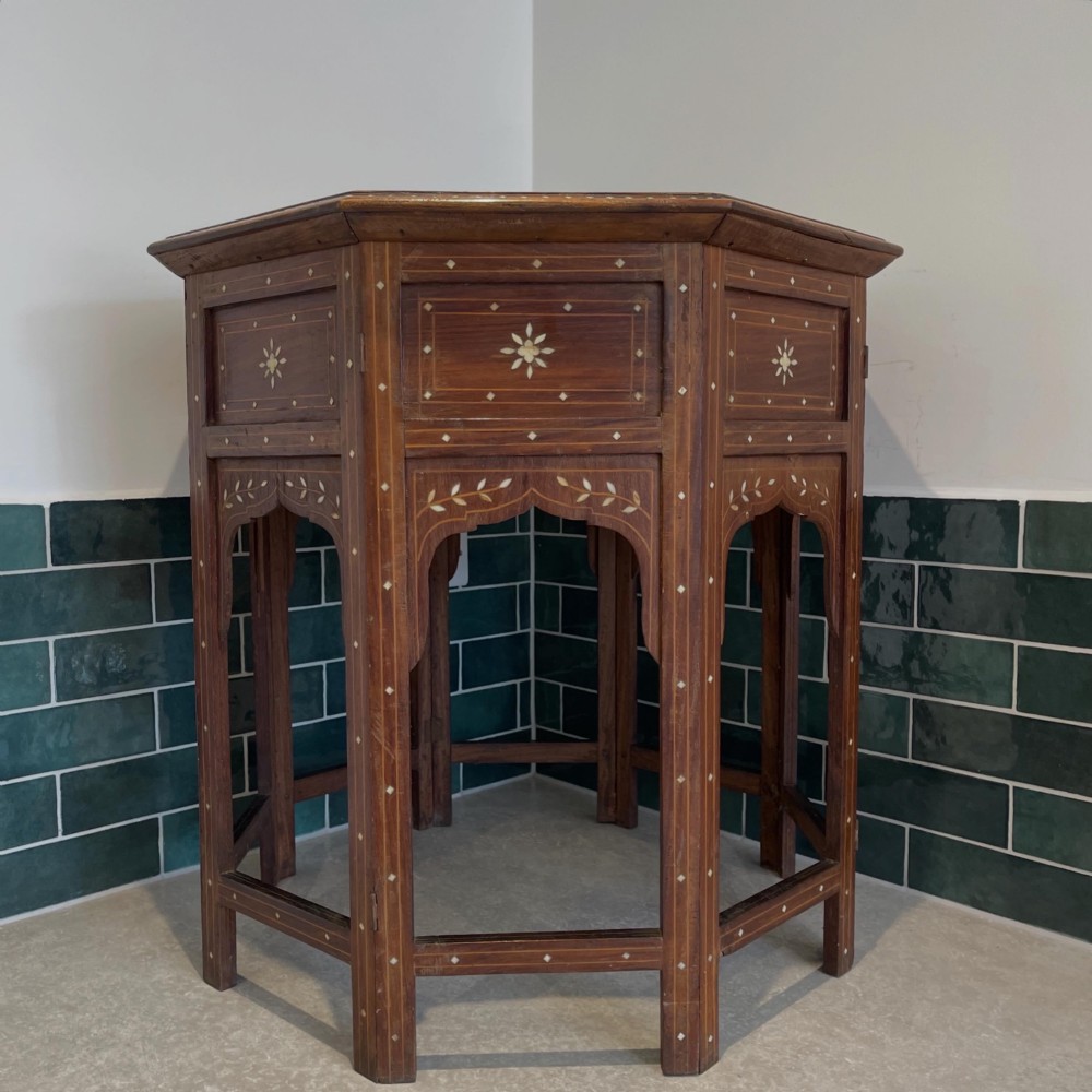 An octagonal Anglo-Indian dark wood side table decorated with dense bone inlay featuring floral patterns, geometric borders, and arched legs. View II