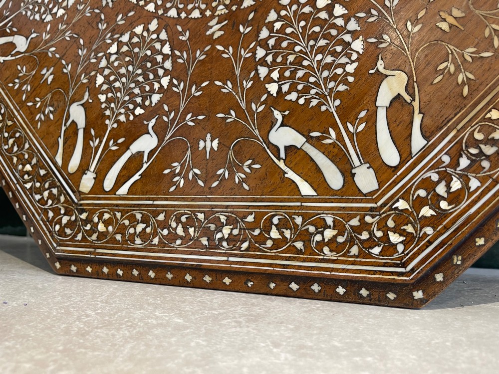 An octagonal Anglo-Indian dark wood side table decorated with dense bone inlay featuring floral patterns, geometric borders, and arched legs. View VI
