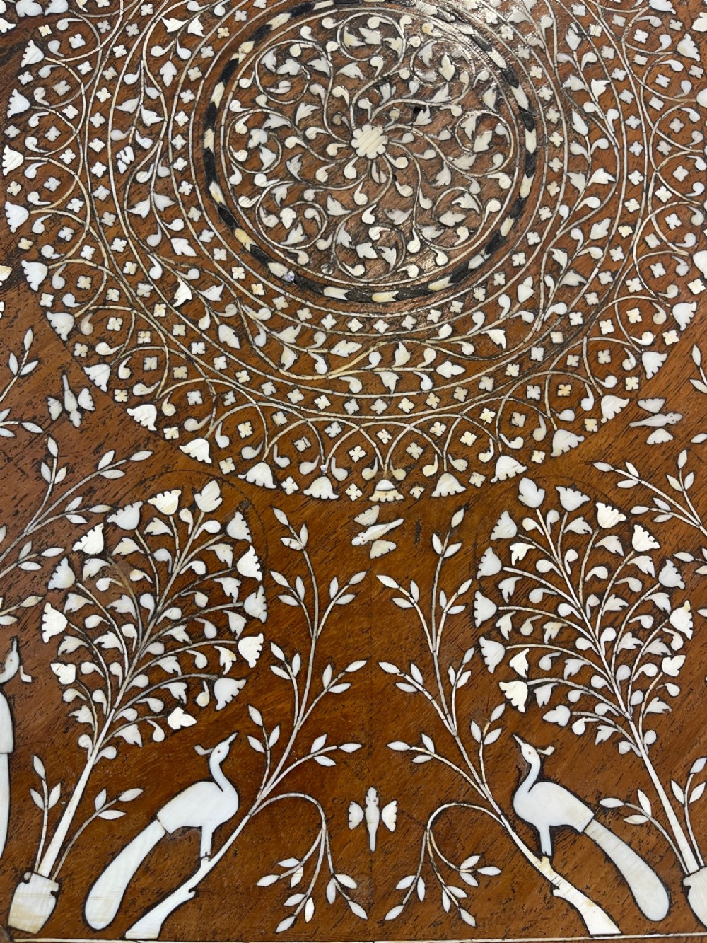An octagonal Anglo-Indian dark wood side table decorated with dense bone inlay featuring floral patterns, geometric borders, and arched legs. View VII