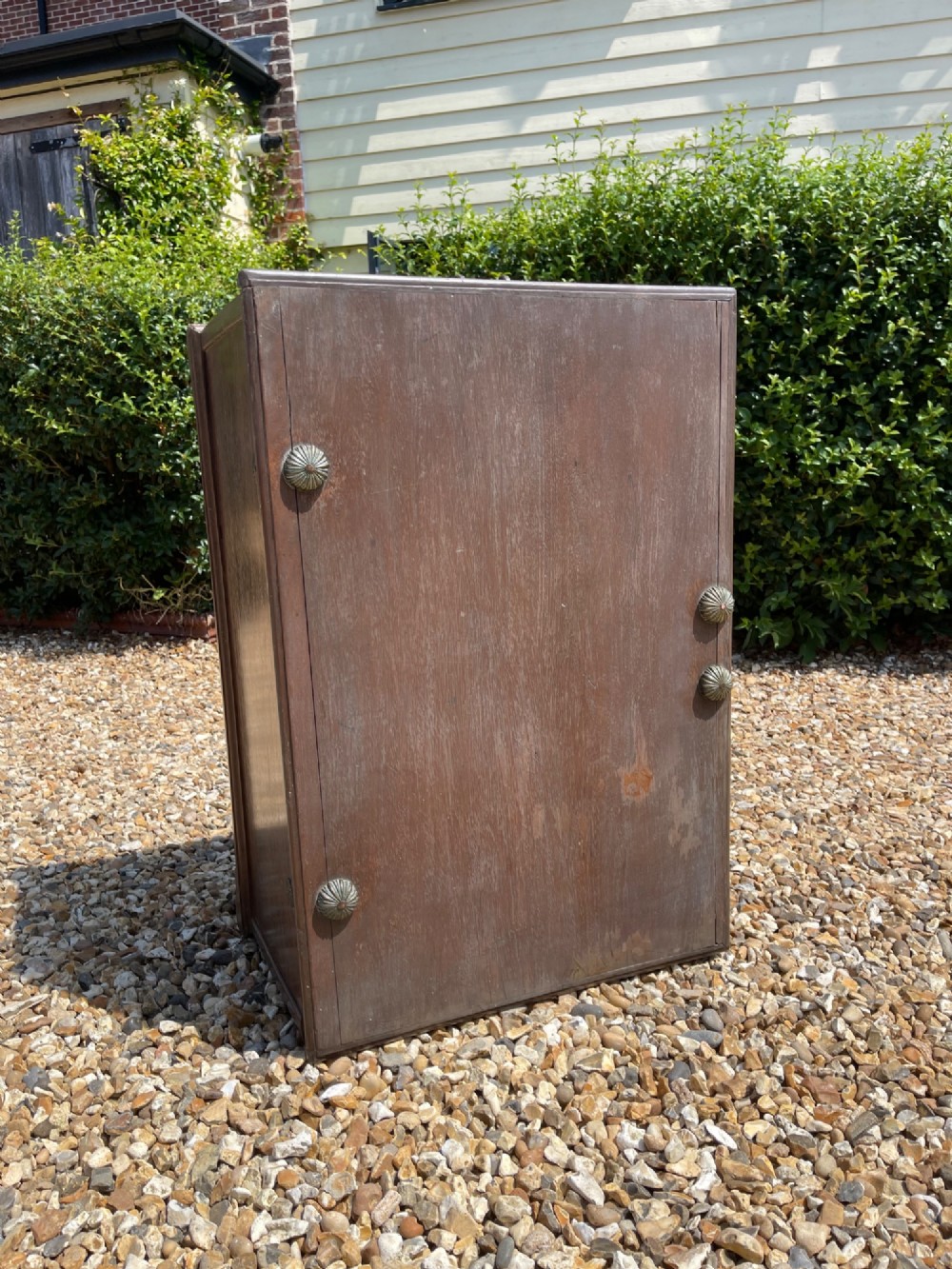 A late eighteenth-century rectangular warm brown teak trunk with a brass keyhole escutcheon, ribbed metal bosses on the lid, and metal side carrying handles. View II