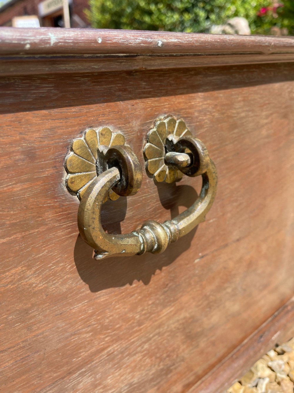 A late eighteenth-century rectangular warm brown teak trunk with a brass keyhole escutcheon, ribbed metal bosses on the lid, and metal side carrying handles. View III