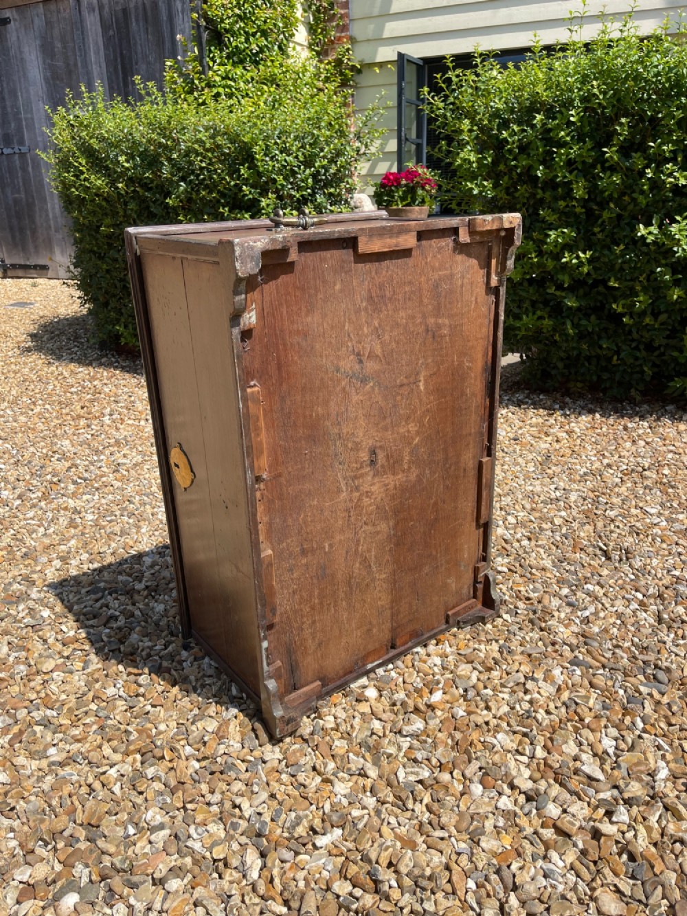 A late eighteenth-century rectangular warm brown teak trunk with a brass keyhole escutcheon, ribbed metal bosses on the lid, and metal side carrying handles. View V