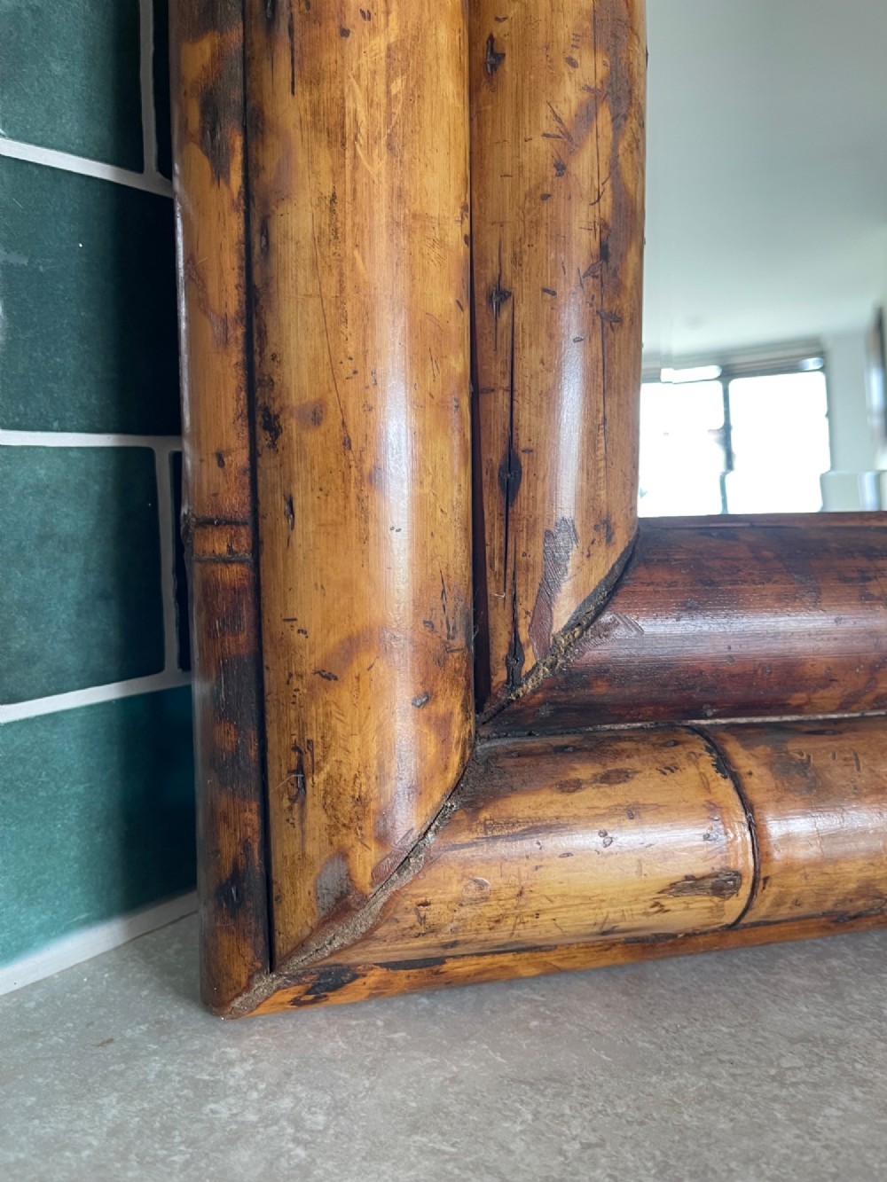 A rectangular wall mirror with a double-layered frame crafted from natural tortoiseshell-patterned bamboo poles. View II