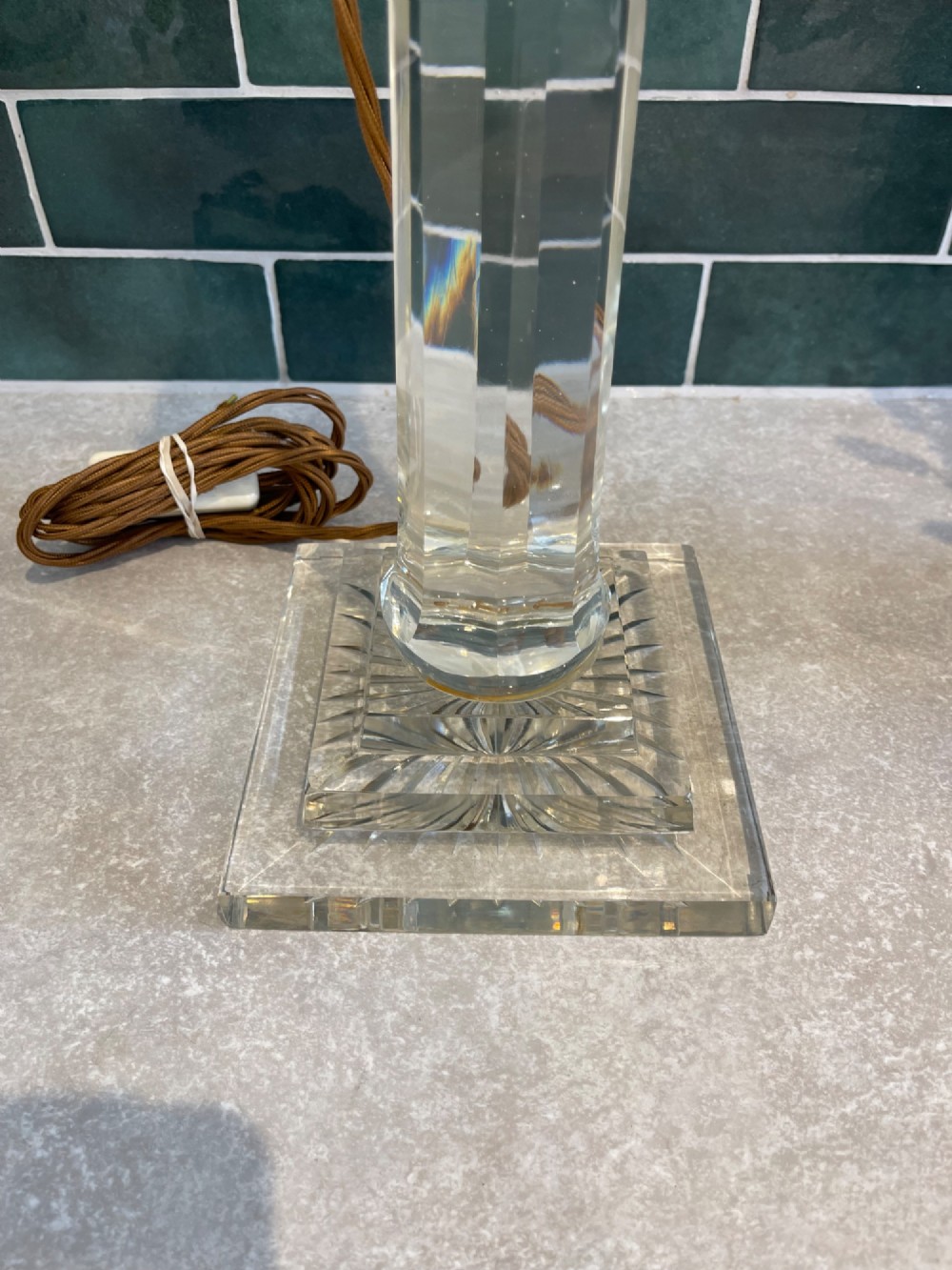 A 19th-century clear cut glass table lamp featuring a brass Corinthian capital mount and a stepped square base. View III