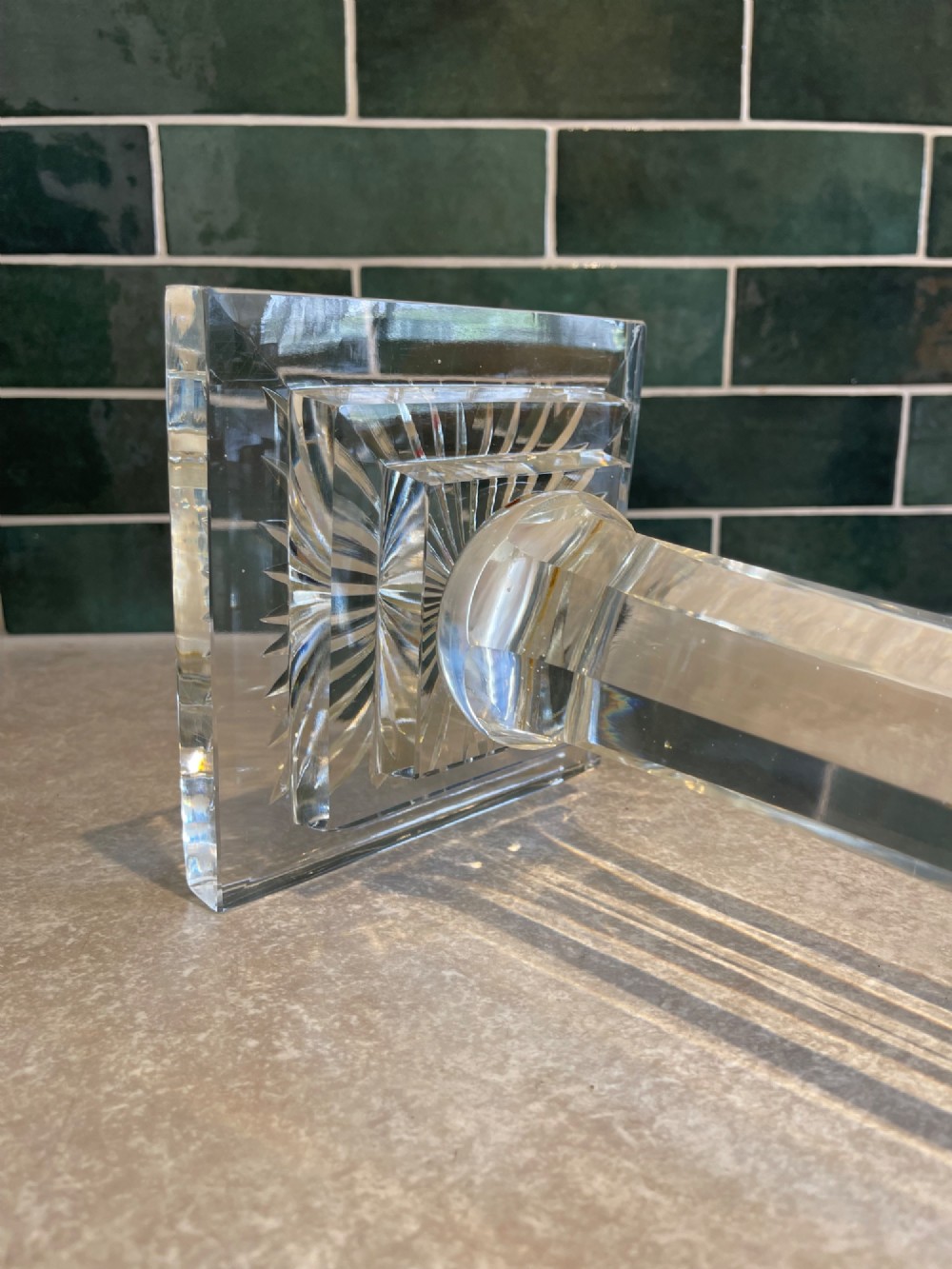 A 19th-century clear cut glass table lamp featuring a brass Corinthian capital mount and a stepped square base. View V