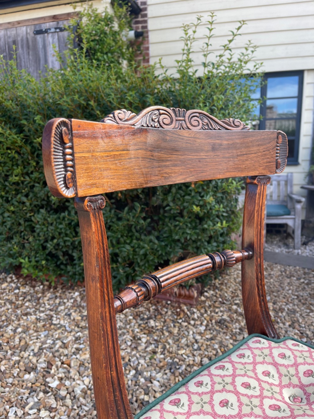 A pair of antique Regency side chairs featuring carved top rails, reeded front legs, and patterned upholstered drop-in seats. View II