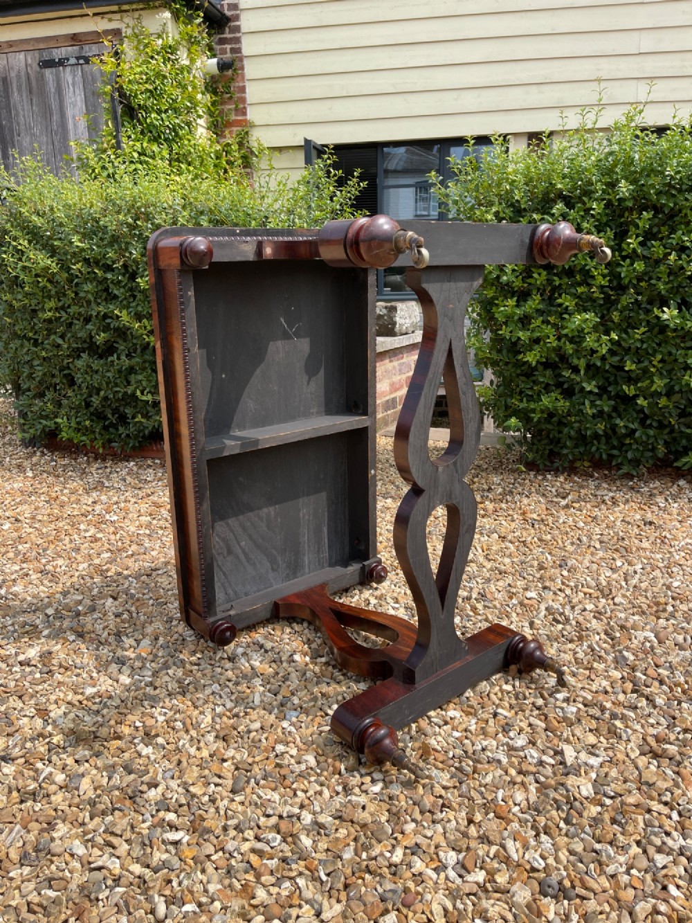 A 19th-century dark wood library table featuring lyre-shaped side supports, a carved central stretcher, beaded moulding, and brass castors. View V