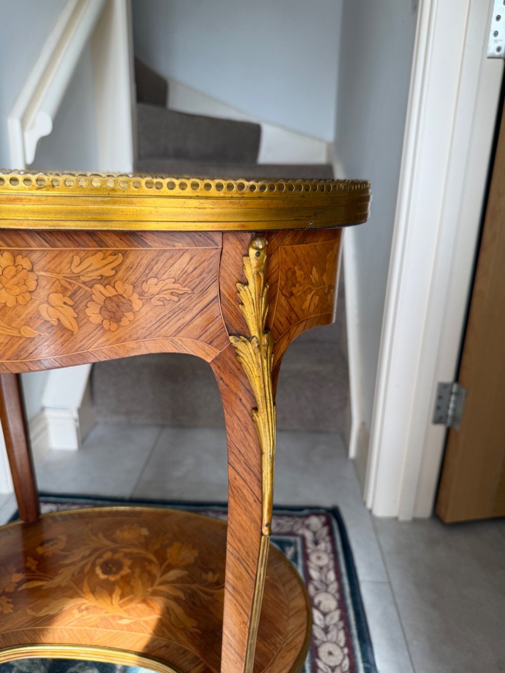An oval French Louis XV style kingwood side table featuring a mottled red marble top, pierced brass gallery, floral marquetry inlay, and cabriole legs with bronze mounts. View VI