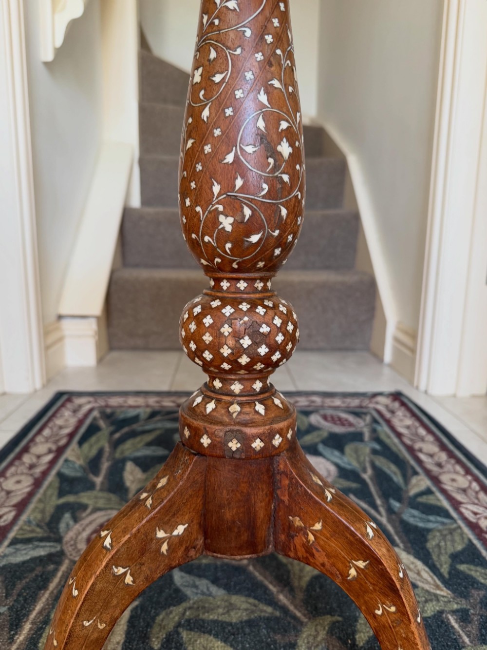 A circular dark wood Anglo-Indian pedestal table featuring intricate bone inlay patterns across the tabletop, turned central column, and tripod feet. View II